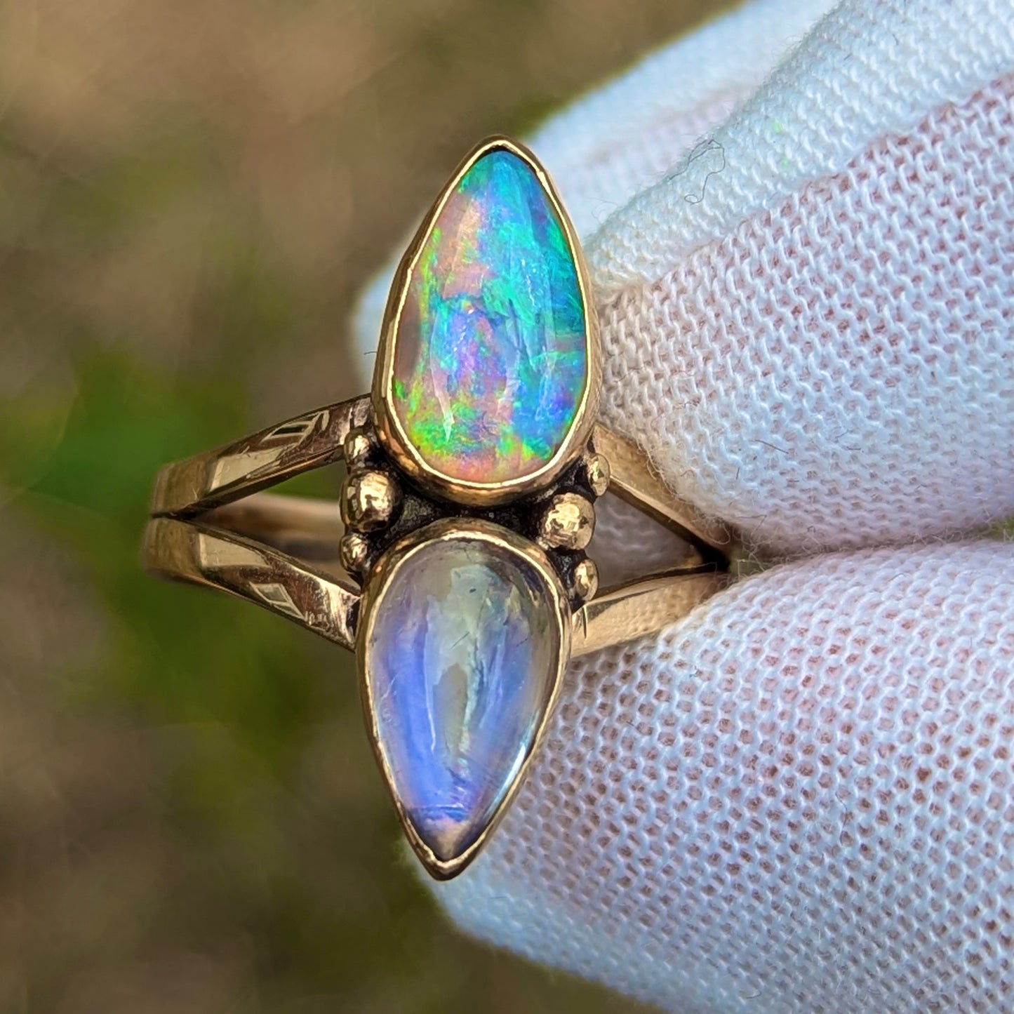 Split shank ring with high grade purple moonstone and green and purple crystal opal in 9K yellow gold