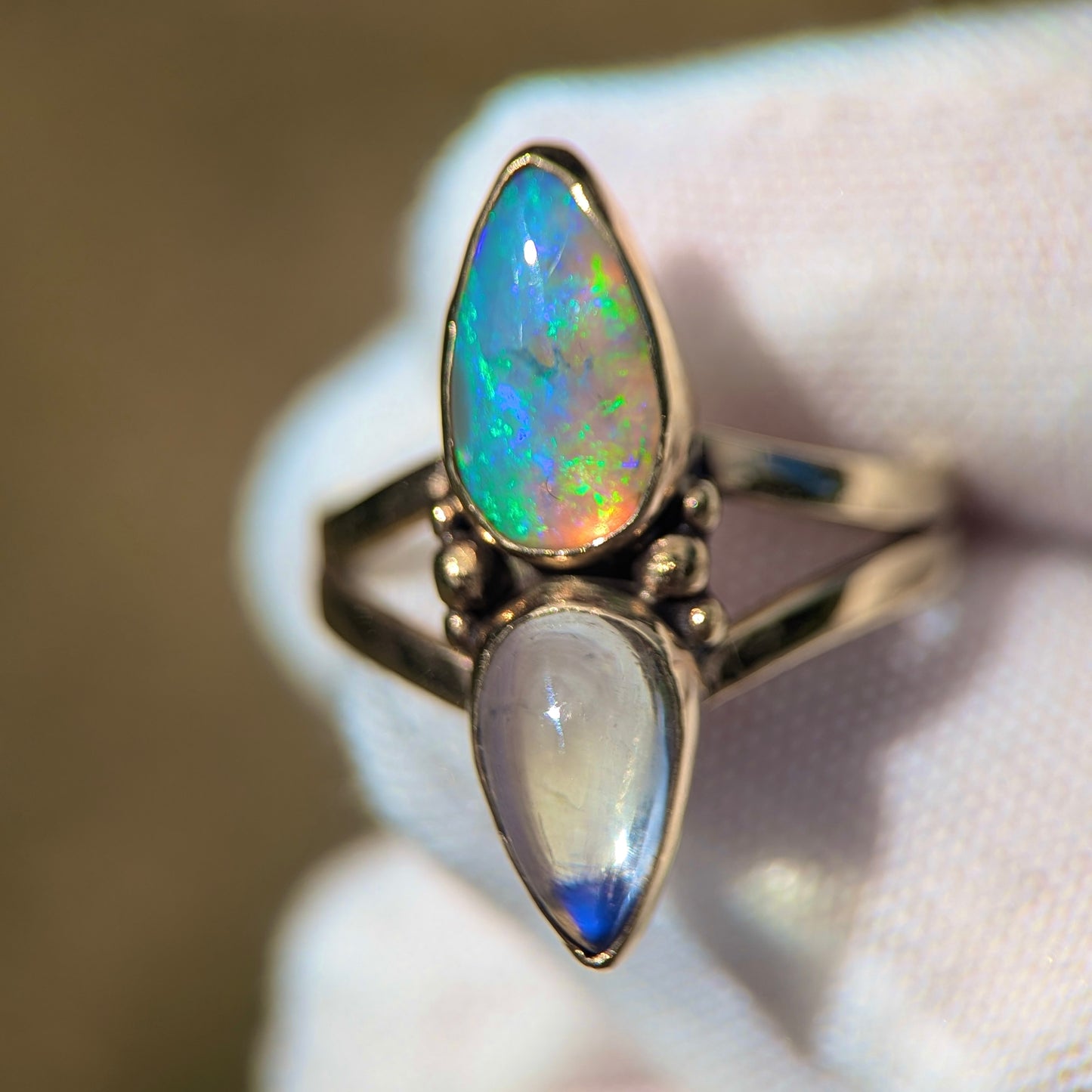 Split shank ring with high grade purple moonstone and green and purple crystal opal in 9K yellow gold